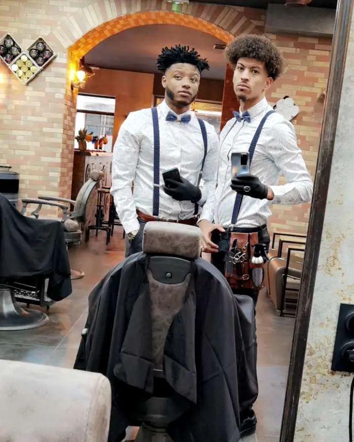 Deux barbiers d'Allure Barber en tenue de travail dans le salon
